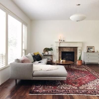 Sofá Elton gris con chaise longue frente a chimenea escandinava – Tienda de Banquitos Argentina