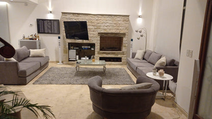 Sofá gris premium en living con chimenea de piedra - Tienda de Banquitos Argentina