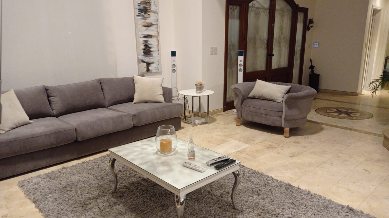 Sofá gris con sillón barrel y pared travertino en living contemporáneo – Tienda de Banquitos Argentina
