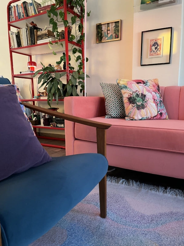 Detalle del apoyabrazos de madera y almohadones del sofá Mila color coral - Tienda de Banquitos