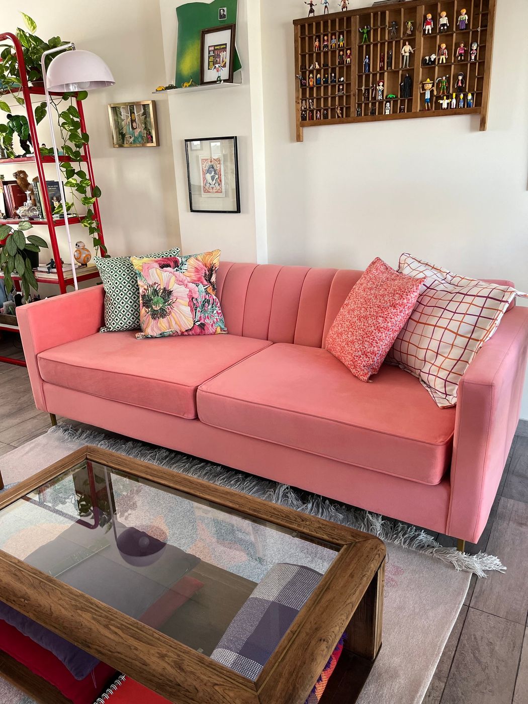 Sofá Mila coral con almohadones estampados, planta y lámpara en el living de Mari