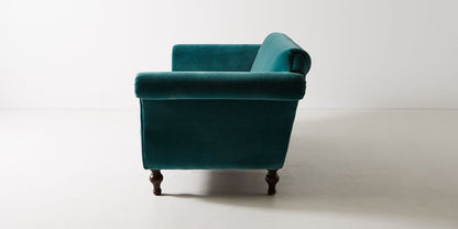 Sofá Rodhesia 2 o 3 cuerpos tapizado en velvet verde petróleo, vista lateral con apoyabrazos enrollado - Tienda de Banquitos