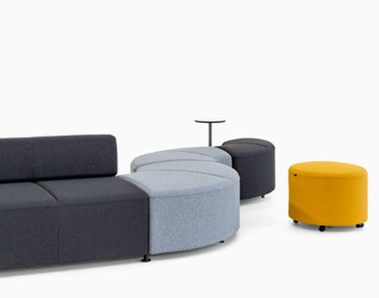Soft seating modular Bend de Archivos Activos: módulos rectos y curvos grises y azules con puff amarillo