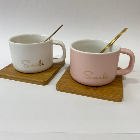 Taza Smile cerámica con cuchara dorada y base de madera - en uso