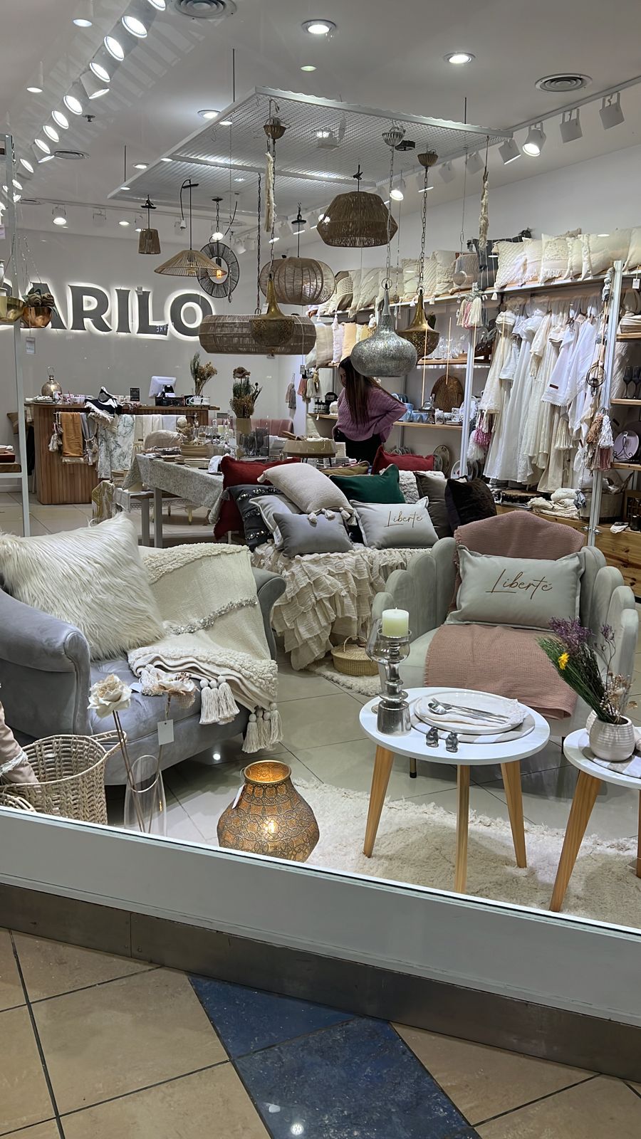 Vidriera de Darilo's Store en el Shopping Portal de la Patagonia, Neuquén, con un Sillón Brigitte gris y un Sillón Angie blanco