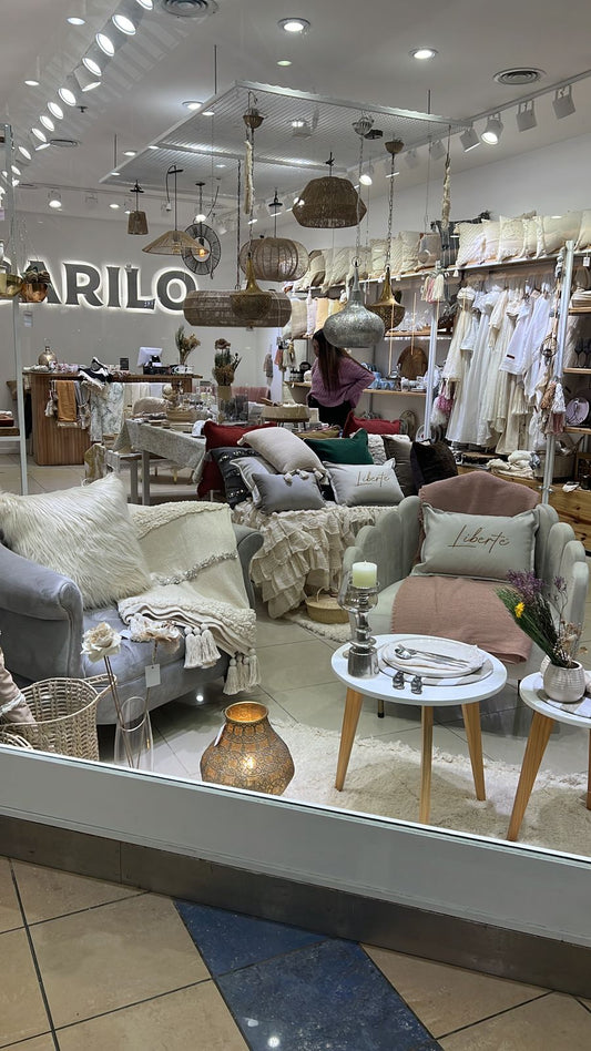 Vidriera de Darilo's Store en el Shopping Portal de la Patagonia, Neuquén, con un Sillón Brigitte gris y un Sillón Angie blanco