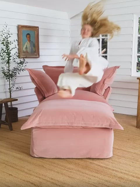 Sillón individual tapizado, de estilo desenfundable, con asiento y respaldo mullidos, acompañado por dos cojines laterales sueltos que aportan volumen y comodidad.
