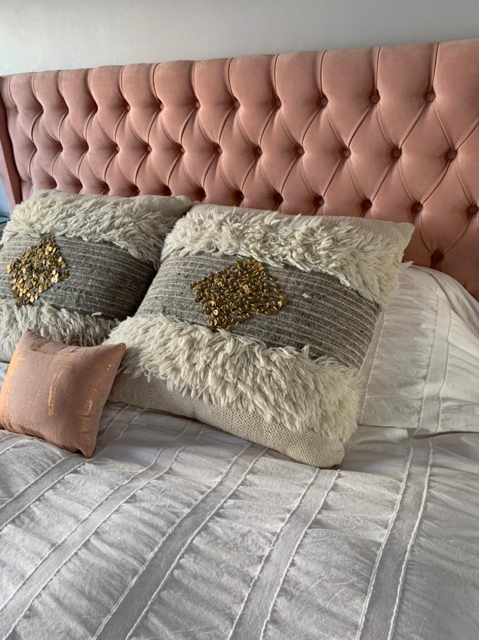 Respaldo alto tapizado en terciopelo rosa suave con diseño capitoné de botones, que aporta un toque elegante y acogedor al dormitorio
