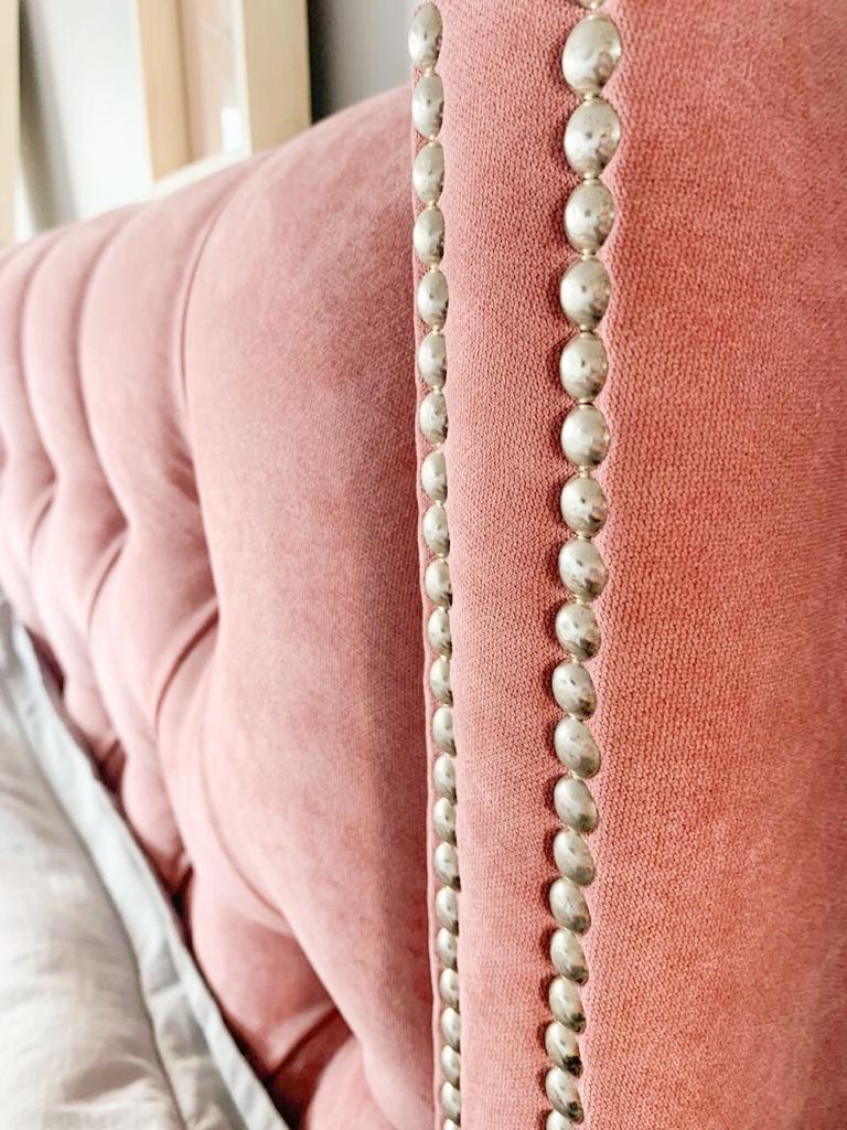 Respaldo de cama con capitoné y orejas con tachas en pana Velutti de De Levie color rosa dior con tachas plateadas