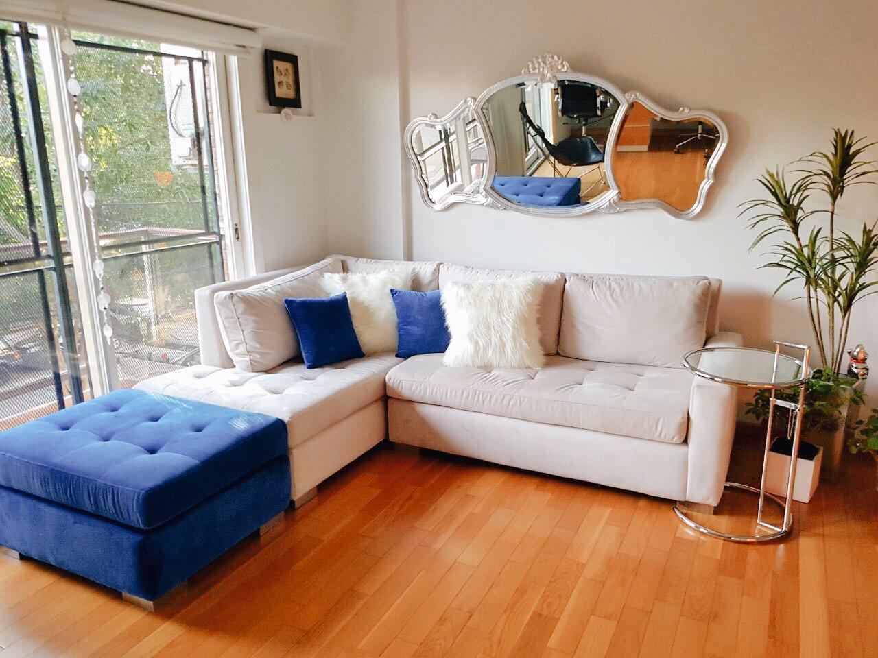 Sillón esquinero con botoné en pana antimancha importada color beige con patas lustre roble claro, con puff en pana Donn azul