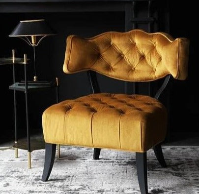 Butaca estilo capitoné en amarillo con respaldo bajo y patas curvadas. Elegancia vintage para espacios infantiles o femeninos.