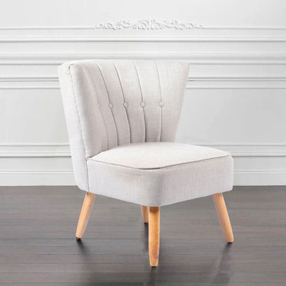 Butaca pequeña tapizada en blanco con respaldo vertical y patas cónicas. Diseño minimalista ideal para niños o espacios reducidos.