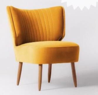 Sillón tapizado con respaldo curvo acanalado y patas de madera clara. Perfecto para espacios infantiles o rincones de lectura.