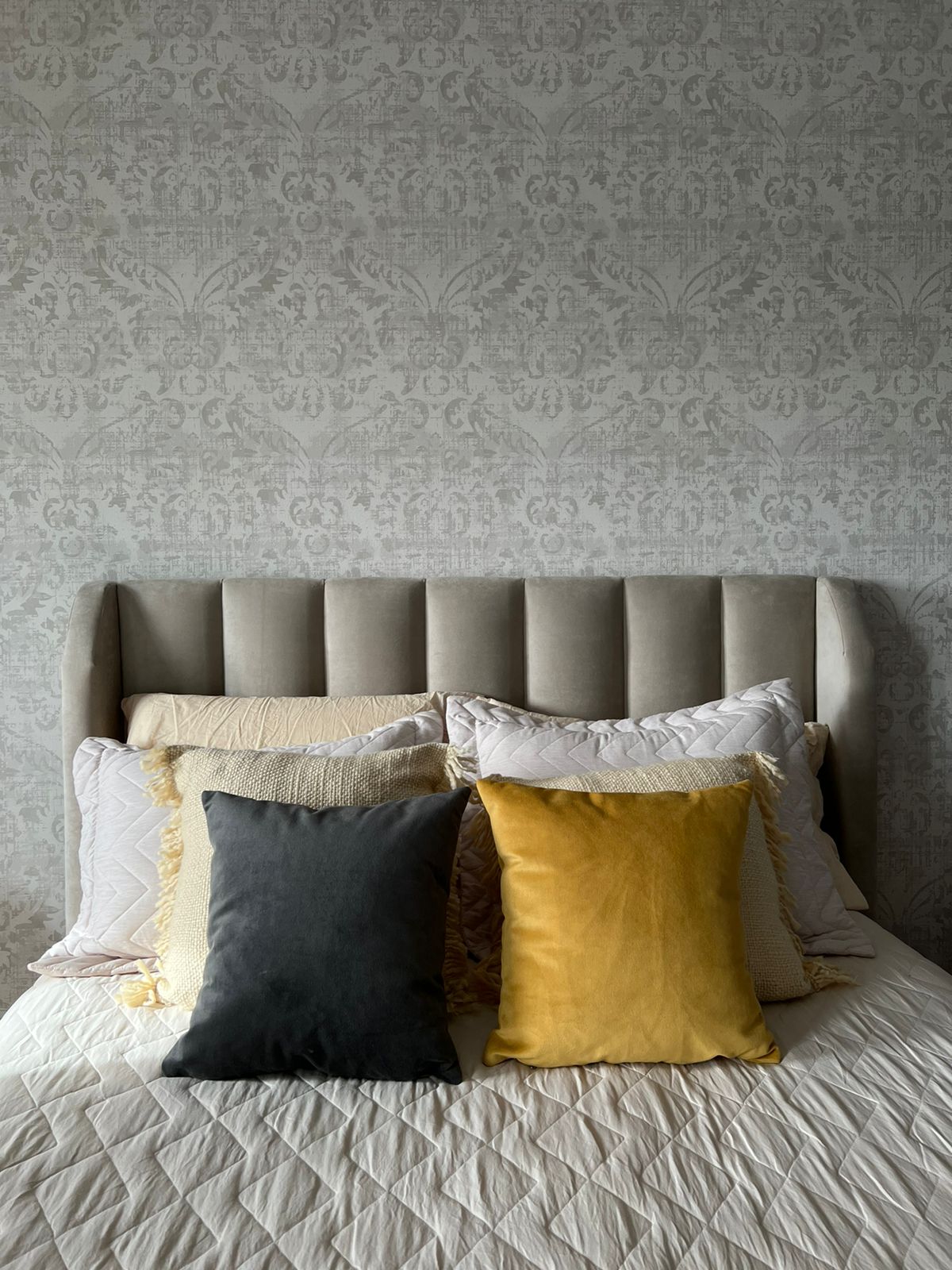 Respaldo de cama modelo Alpes con orejas laterales, tapizado acolchado y estilo elegante que envuelve la zona de descanso.