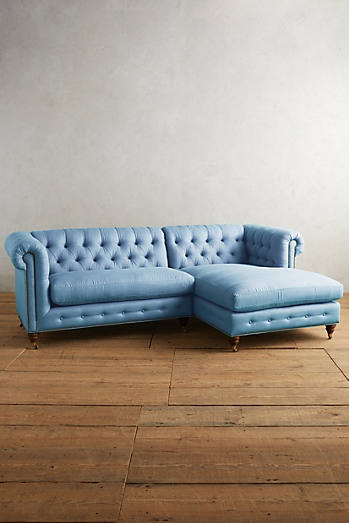 Sillón esquinero estilo Chesterfield en pana celeste con capitoné, brazos curvos y patas altas. Clásico inglés con personalidad.