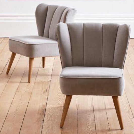 Sillón matero Alpes tapizado liso con respaldo acolchado en gajos verticales y patas de madera natural. Diseño moderno y cómodo para espacios pequeños.