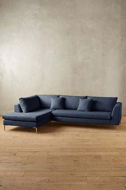 Sofá esquinero Bélgica con patas doradas y diseño moderno; CyberMonday con descuentos y cuotas sin interés.