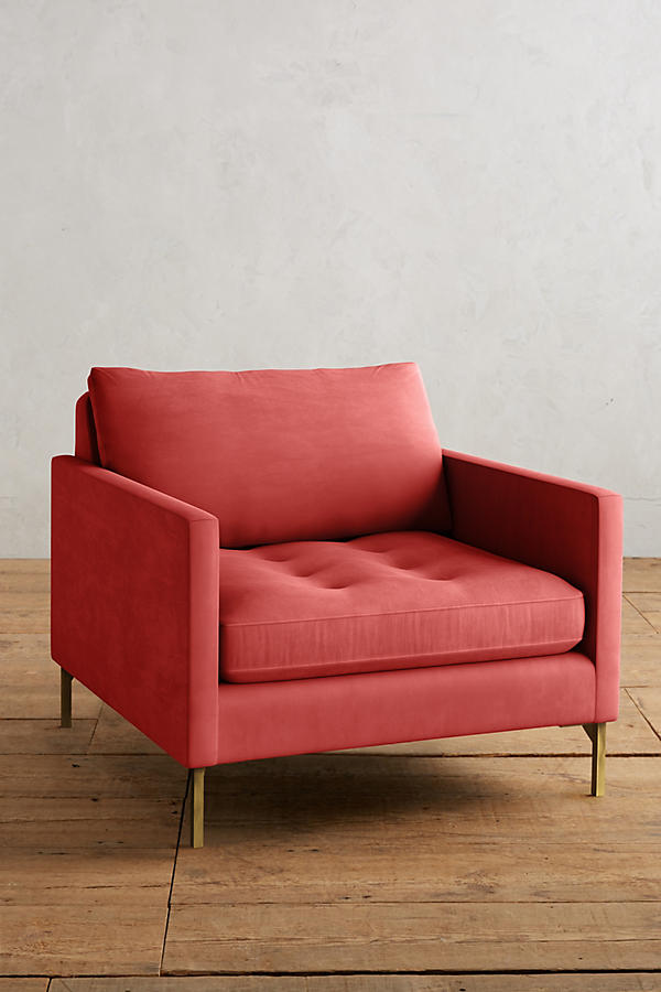 Sillón individual moderno en color rojo con respaldo y asiento acolchados, apoyabrazos rectos y patas metálicas finas en dorado, sobre fondo blanco.