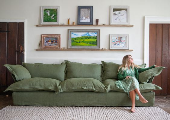 Sofá Comfy enfundado, con respaldo y apoyabrazos integrados, amplios cojines extra mullidos en asiento y respaldo, líneas suaves y estructura de base baja, presentado sobre fondo blanco, ideal para livings contemporáneos o espacios de descanso que buscan máxima comodidad y estilo relajado.