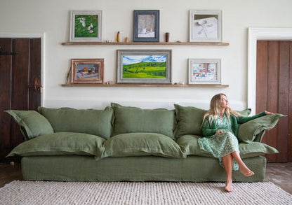 Sofá Comfy enfundado, con respaldo y apoyabrazos integrados, amplios cojines extra mullidos en asiento y respaldo, líneas suaves y estructura de base baja, presentado sobre fondo blanco, ideal para livings contemporáneos o espacios de descanso que buscan máxima comodidad y estilo relajado.