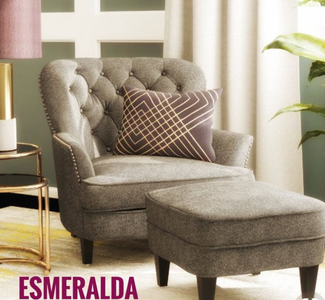 Sillón clásico tapizado en color marron con respaldo capitoné curvo, asiento acolchado y patas de madera cónicas.