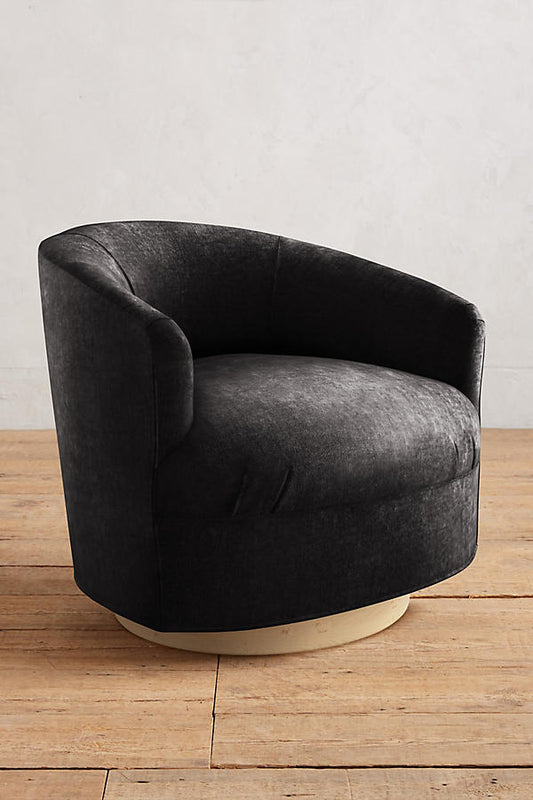 Sillón individual moderno con forma redondeada y base giratoria, tapizado en negro.