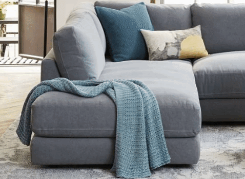 Sillón esquinero amplio en gris claro, almohadones grandes y asiento profundo. Confort máximo en estilo contemporáneo.