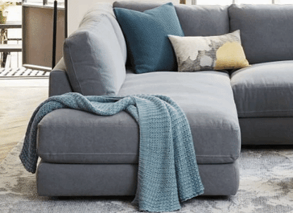 Sillón esquinero amplio en gris claro, almohadones grandes y asiento profundo. Confort máximo en estilo contemporáneo.