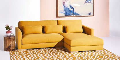 Sillón esquinero en tono amarillo, con respaldo y apoyabrazos rectos. Toque retro con estilo actual.