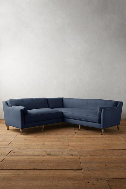 Sillón esquinero de diseño liviano en azul, estructura baja y líneas minimalistas. Ideal para ambientes femeninos y luminosos.