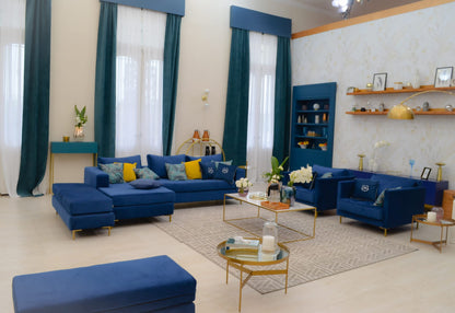 Sillón esquinero moderno en azul con patas doradas, líneas limpias y almohadones sueltos. Estilo nórdico con toque glam.