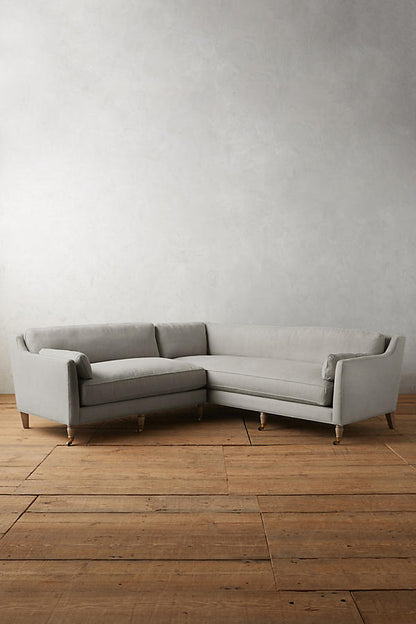Sillón esquinero de diseño liviano en gris, estructura baja y líneas minimalistas. Ideal para ambientes femeninos y luminosos.