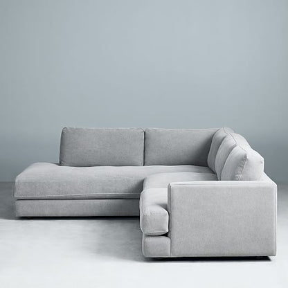 Sillón esquinero amplio en gris claro, almohadones grandes y asiento profundo. Confort máximo en estilo contemporáneo.