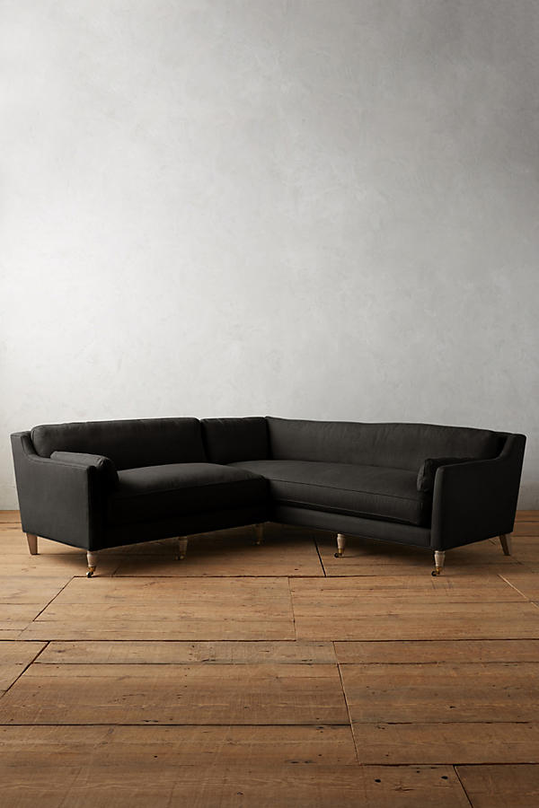 Sillón esquinero de diseño liviano en negro, estructura baja y líneas minimalistas. Ideal para ambientes femeninos y luminosos.