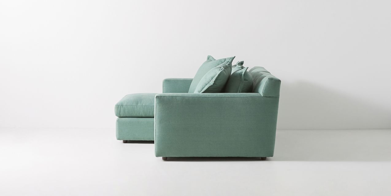 Sillón esquinero verde con apoyabrazos rectos, estructura firme y respaldo mullido. Perfecto para livings amplios.