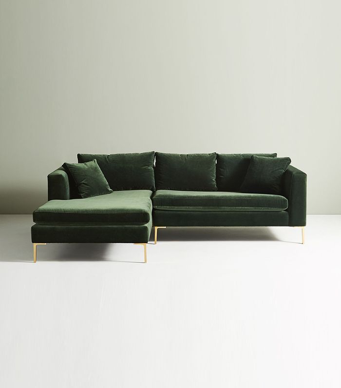 Sillón esquinero moderno en verde con patas doradas, líneas limpias y almohadones sueltos. Estilo nórdico con toque glam.