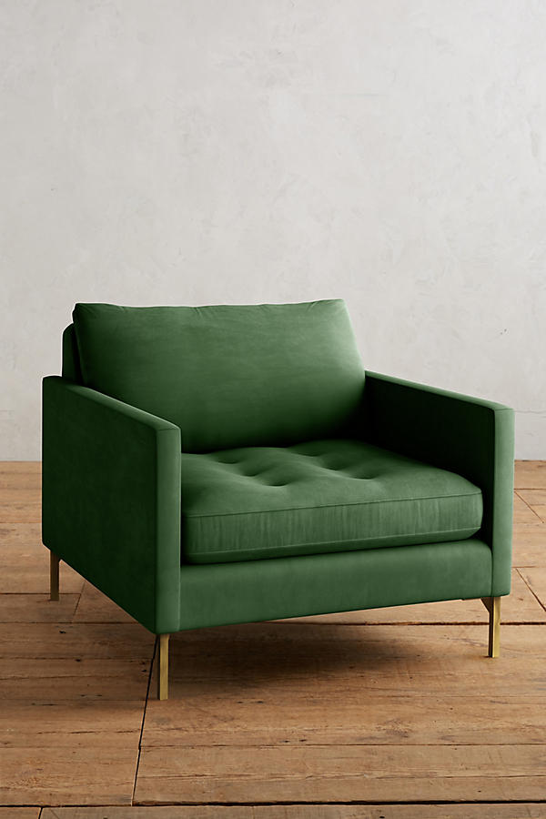 Sillón individual moderno en color verde con respaldo y asiento acolchados, apoyabrazos rectos y patas metálicas finas en dorado, sobre fondo blanco.