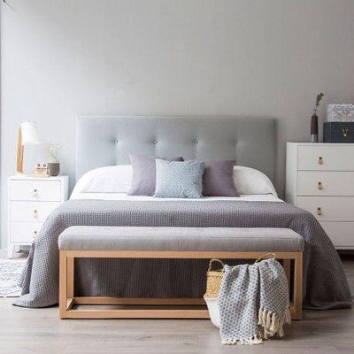 Respaldo de cama con botoné color gris.