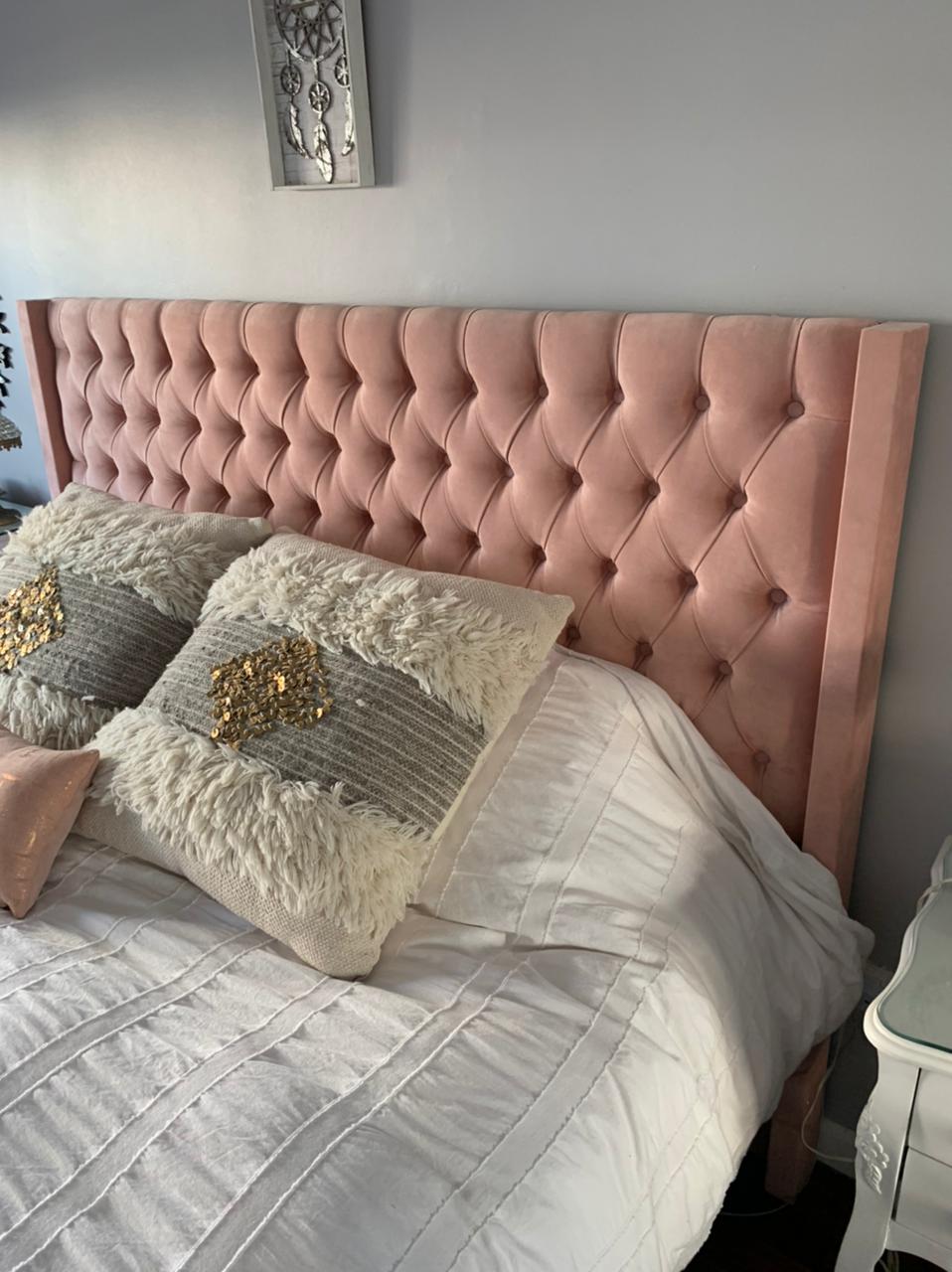 Respaldo alto tapizado en terciopelo rosa suave con diseño capitoné de botones, que aporta un toque elegante y acogedor al dormitorio