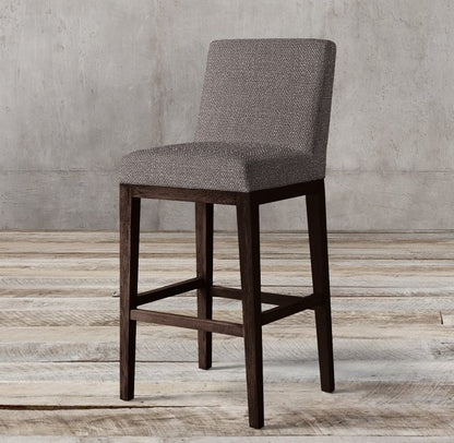 Banqueta Alta Cala en gris con patas de madera oscura y respaldo bajo