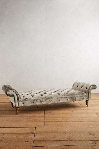 Banqueta Pie de Cama Chesterfield beige con capitoné y brazos enrollados, sobre piso de madera