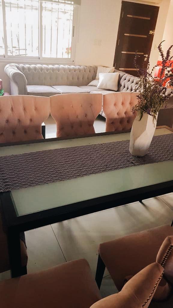 Comedor con sillas rosas y el Esquinero Chesterfield de fondo, en la casa de Guillermina
