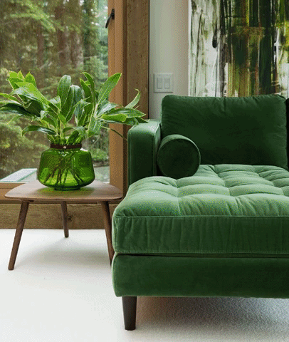 Detalle del chaise longue del Sillón esquinero Bambú en verde, con almohadón cilíndrico y patas de madera