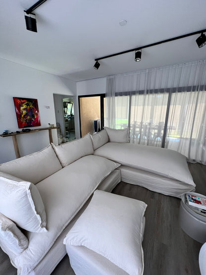 Vista del Esquinero Comfy de Maxi con almohadones sueltos, chaise a la derecha y puff al tono sobre piso de madera