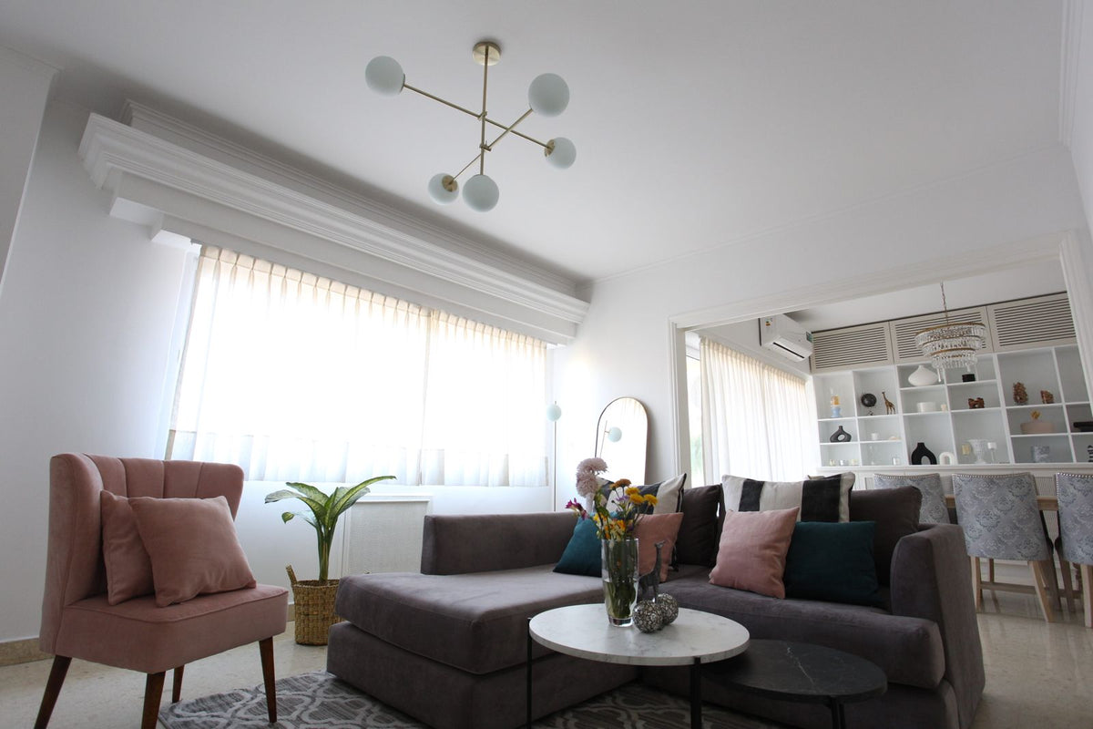 Vista amplia del living de Naza Winograd con el Esquinero Elton gris malva, el Sillón Matero Alpes rosa y el comedor de fondo