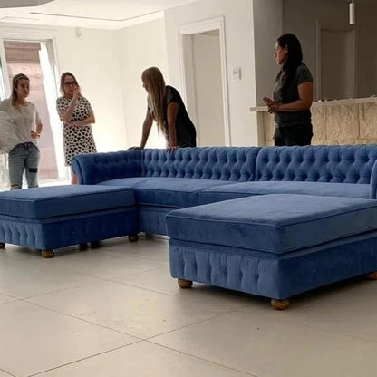 Sillón esquinero de gran tamaño tapizado en terciopelo azul, con diseño moderno y patas de madera, ideal para destacar en un living amplio y elegante.