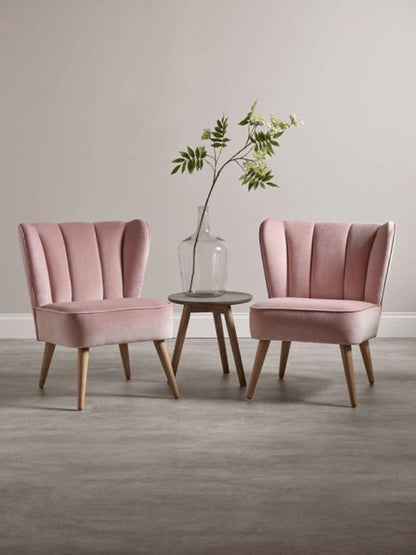 Dos Sillones Matero Alpes rosa claro con una mesa auxiliar redonda de madera