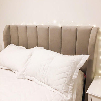 Franjas verticales del Respaldo Alpes gris con almohadones blancos, en el dormitorio de Martha