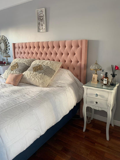 Respaldo Emmy rosa con capitoné en el dormitorio de Camila, con mesa de luz blanca de estilo francés