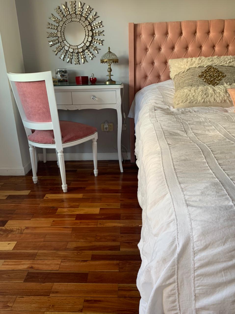 Respaldo Emmy rosa junto al tocador blanco, el espejo sol y la silla rosa en el dormitorio de Camila